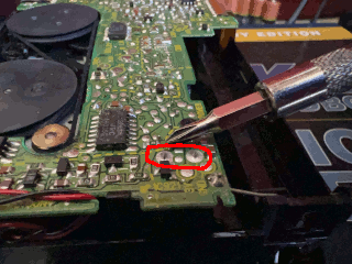 Photo of a screwdriver discharging the PRAM capacitor in a Sony Walkman WM-F2085