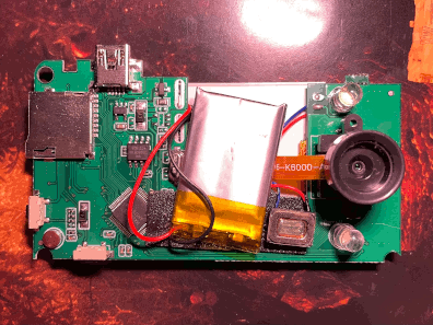 Photo of the camera's circuit board, with a lens unit and Li-Po battery visible